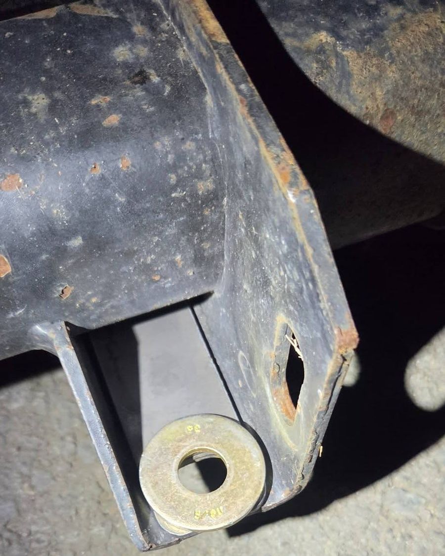 A large washer at an axle mount under a trailer